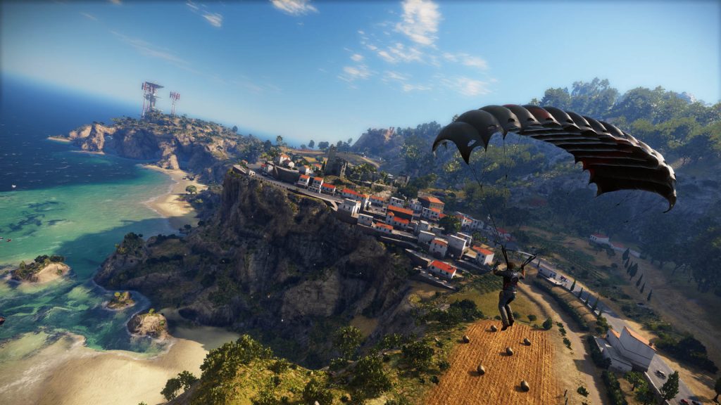 A parachute above a coastal landscape and settlement in Just Cause 3.